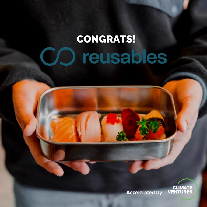 Close-up photo of a person holding up a reusable container filled with sushi. Text overlay, "Congrats! Reusables." In bottom right corner, "Accelerated by Climate Ventures."