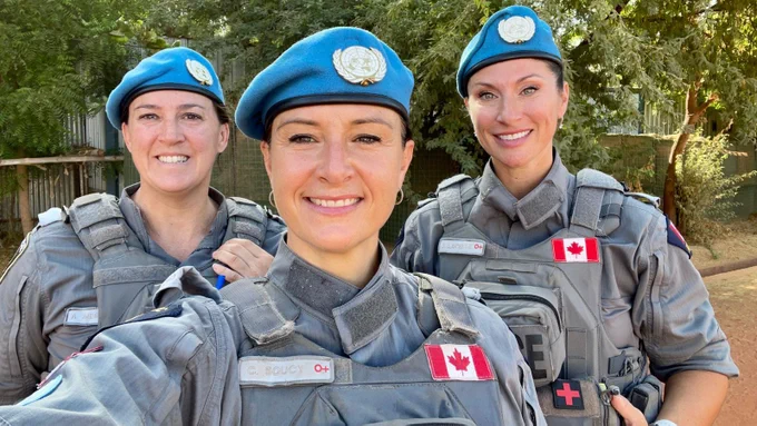 3 Canadian women police officers smile at the camera while taking a selfie outside in Mali.