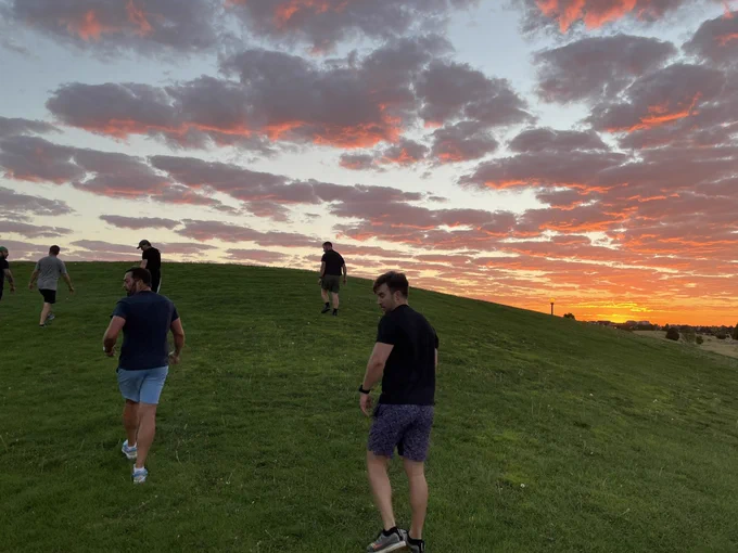 5 guys walking backwards down a hill.