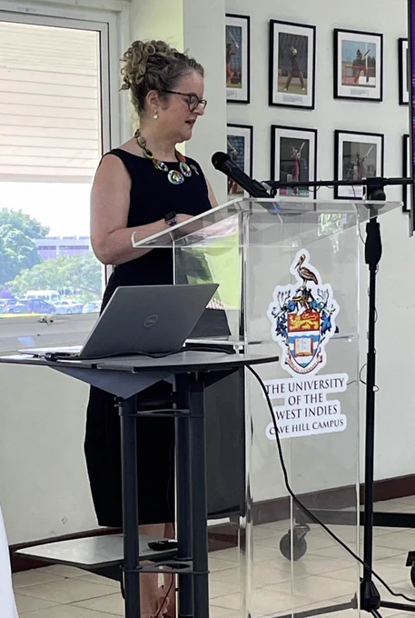 Anna standing at a podium at UWI.