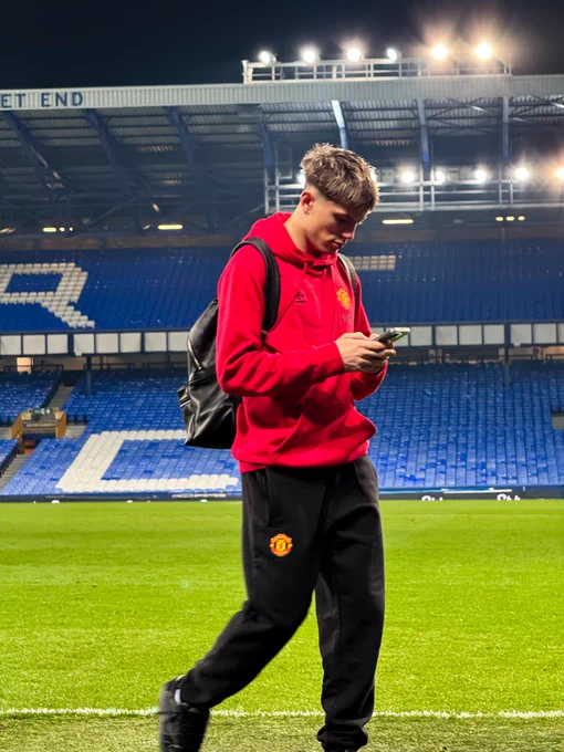 Alejandro Garnacho leaves Goodison Park while checking his phone.