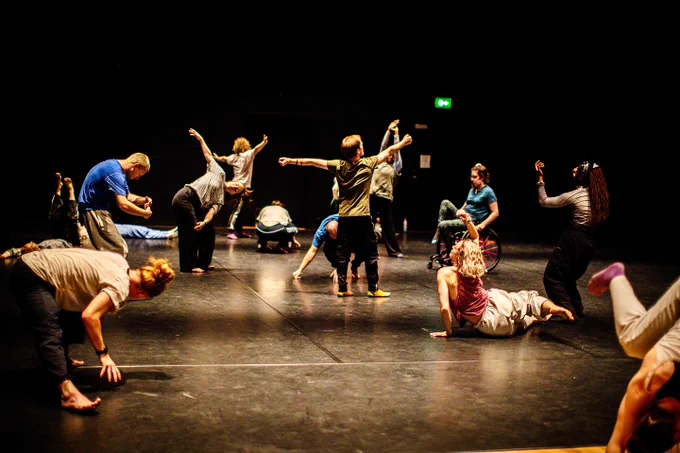 group of dancers moving in a large blackout space. Photo taken by Pani Orzechova