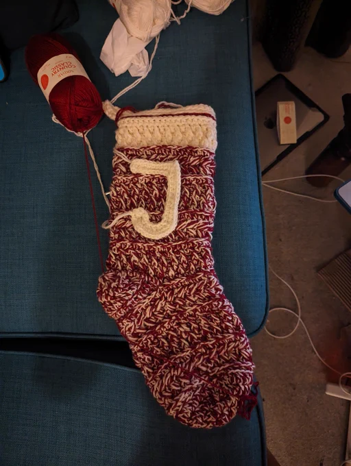 The same stocking with a large crochet capital J pinned onto it.