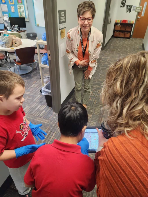 Student using AAC device to deliver coffee. 