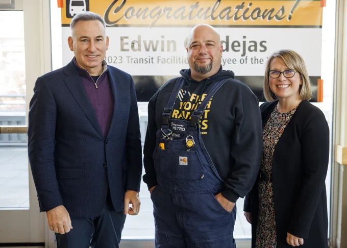 Executive Constantine, Metro Facilities Employee of the Year Ed Cendejas and Metro General Manager Michelle Allison stand in front of a congratulations banner.