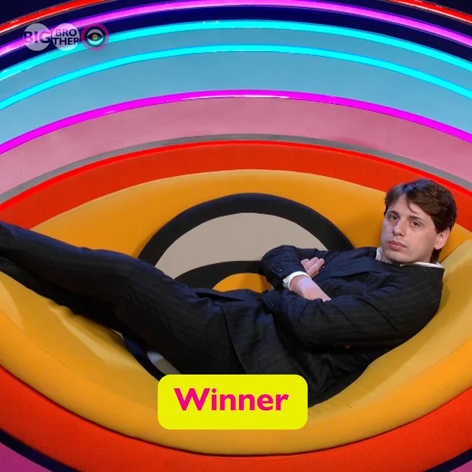 Jordan laying across the Big Brother Diary Room chair, wearing a suit.
