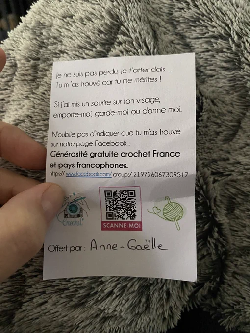 Un papier sur lequel il est écrit « je ne suis pas perdu, je t’attendais… tu m’as trouvé car tu le méritées ! Si j’ai mis un sourire sur ton visage, emporte moi, garde-moi ou donne-moi. N’oublie pas d’indiquer que tu m’as trouvé sur notre page Facebook « générosité gratuité crochet France et pays francophones » https://www.Facebook.com/groups/219726067309517 il y a un QR code et en bas il est écrit : offert par Anne-Gaëlle