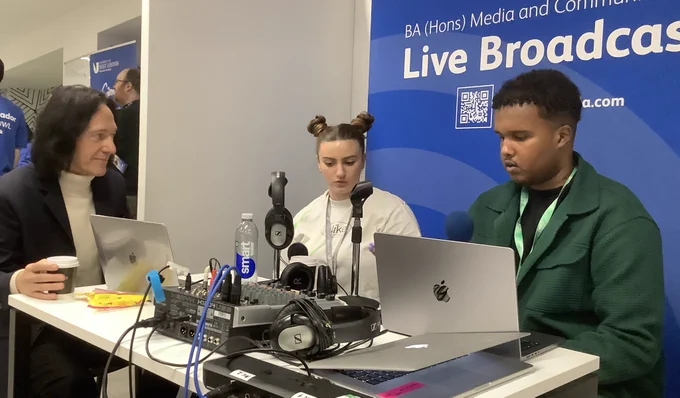 Two Media and Communications students from the University of West London interviewing Dr John Hillman. Picture shows them using microphones, headphones, portable mixing desk and computers.