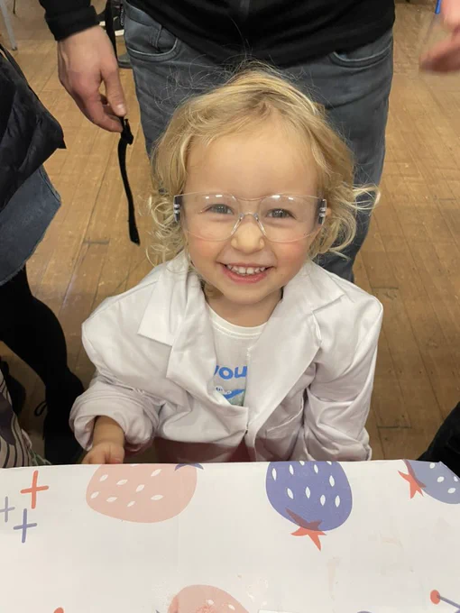 Tiny Toddler scientist wearing a lab coat and goggles