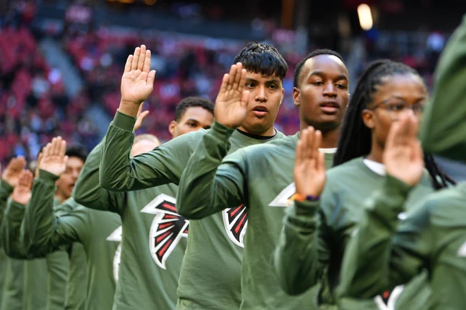 New recruits and current service members take the oath of enlistment during the Atlanta Falcons’ Call to Service event in Atlanta.
