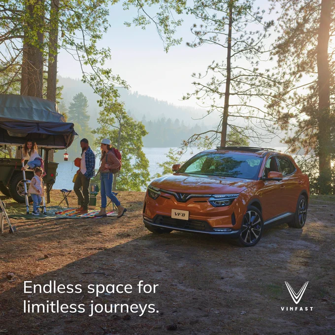 orange electric car with people in the mountain