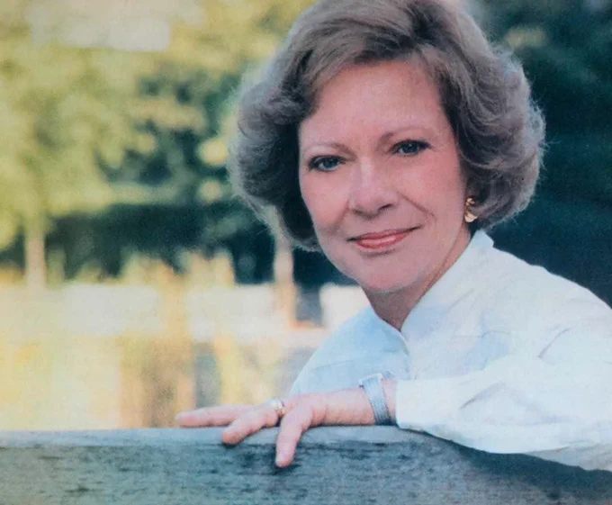First Lady Rosalynn Carter wearing a white top smiling at the camera
