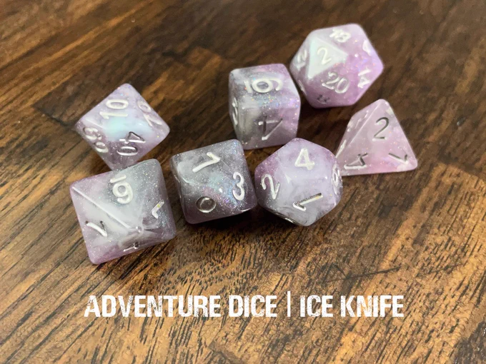 Ice Knife dice set is a sparkly, wispy swirl of grey and purple, with silver numbering.