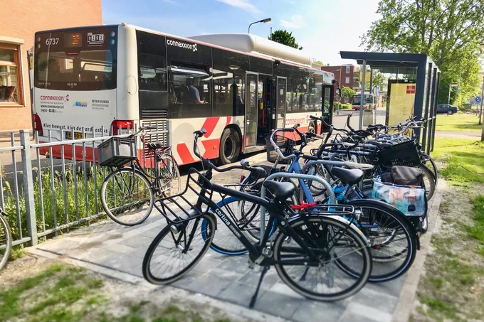 Parked bicycles by a bus stop in Delft