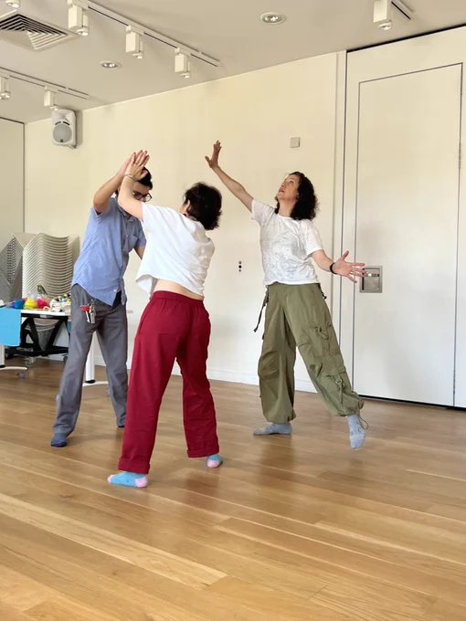Three people exploring movement during a workshop