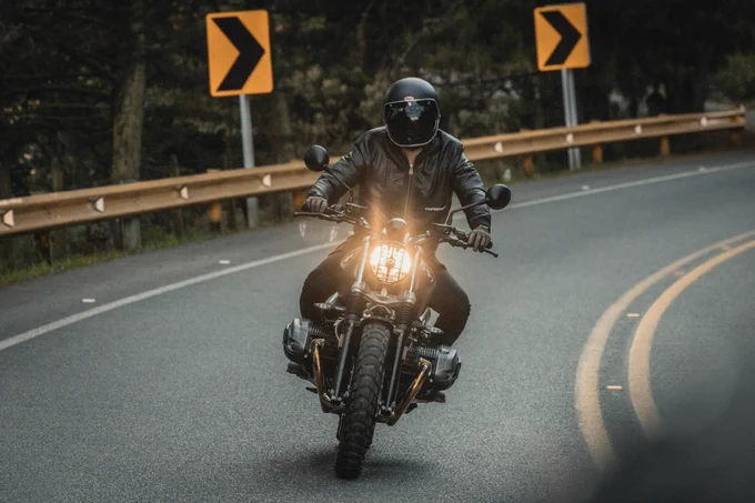 A motorcyclist rides down the road on their motorcycle