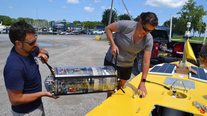 NOAA GLERL Scientist Dr. Reagan Errera (right) and Marine Engineer Kyle Beadle removing MBARI’s 3G ESP sampling robot from the inside of the SeaTrac. photo credit: NOAA/Kelly Goodwin