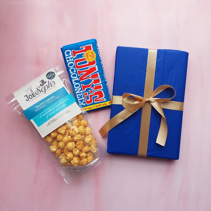 image of The Man of Her Dreams prize draw items: book, chocolate bar, popcorn
