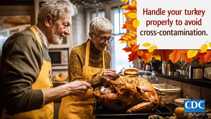 An older male and female couple in a kitchen dressing a cooked whole turkey. Text overlay states, “Handle your turkey properly to avoid cross-contamination”. 