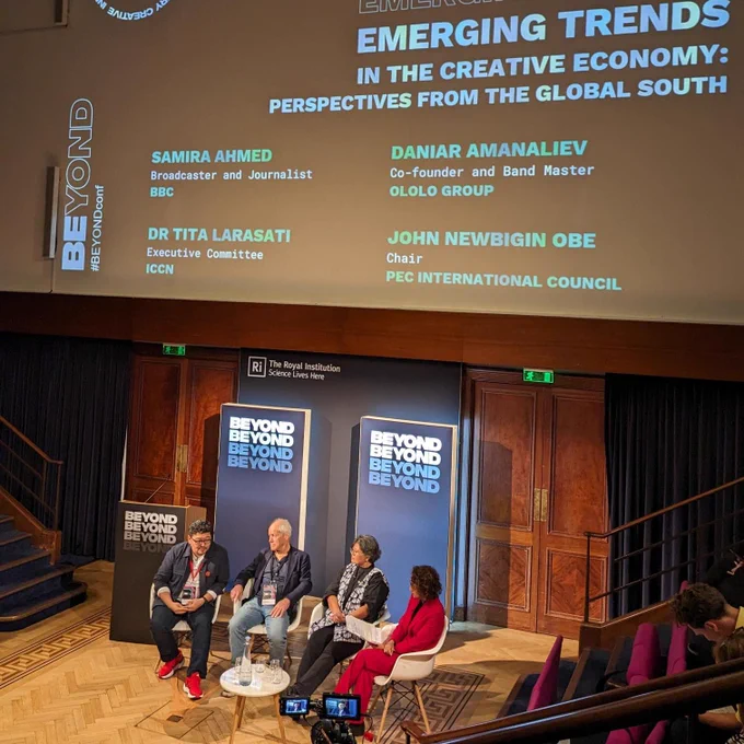 A panel of two men and two women sit on the stage of the Royal Institution, with the BEYOND branding behind them. The session title is Emerging Trends In the Creative Economy: Perspectives from the Global South.