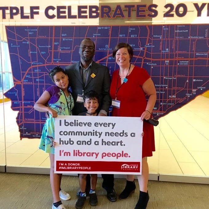 An image of Jackson with his family holding up a sign

Text
"I believe every community needs a hub and a heart. I'm library people"