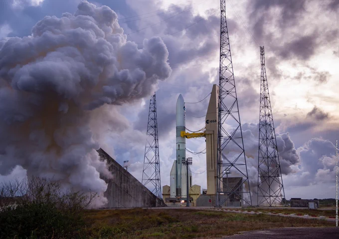 Backdropped by a cloudy Kourou sky, clouds of steam surround the Ariane 6 test vehicle during the hot-fire test on 23 November. The running engine can just be seen as a bright yellow spot at the base of the rocket. 
