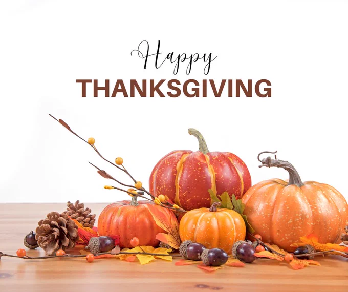 Photo of an arrangement of decorative pumpkins and acorns. "Happy Thanksgiving."