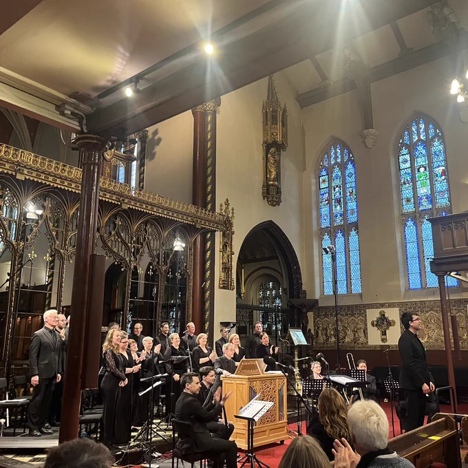 The BBC Singers, English Cornett & Sackbut ensemble, organist Stephen Farr and conductor Owain Park taking a bow in an ornately decorated church.