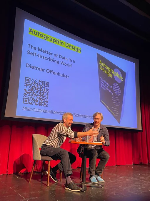 Dietmar Offenhuber and myself sitting at a table on stage, discussing shared themes among our books.