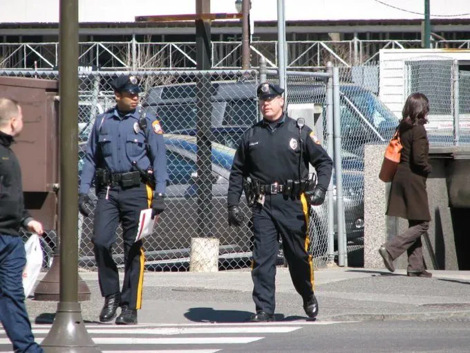 Two police officers cross a crosswalk.