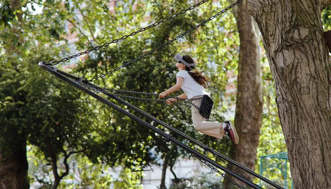 A young person swinging on the Studio GoGo Volo: Dreams of Flight virtual reality ride 