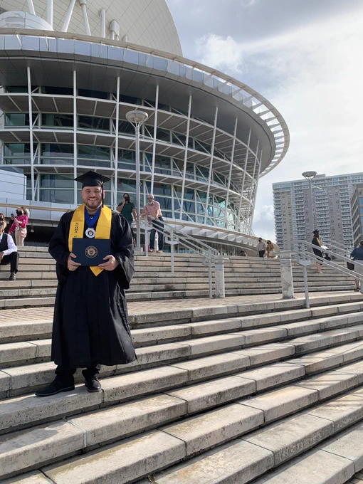 A photo of me with my graduation gown in front of the Coliseo de Puerto Rico.