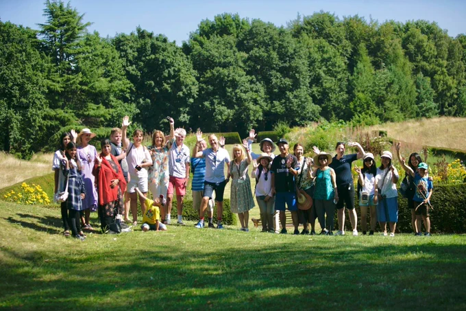 Large group of people in a garden waving in the sunshine 