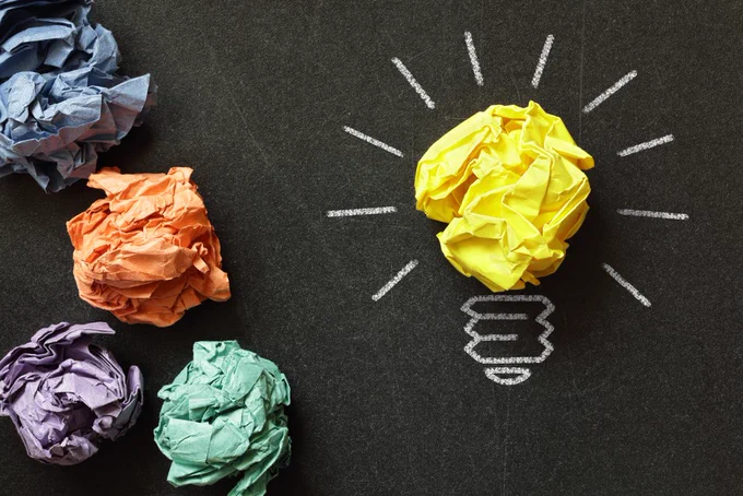 image of  yellow light bulb made out of yellow crumpled paper. 4 other crumpled paper balls adjacent