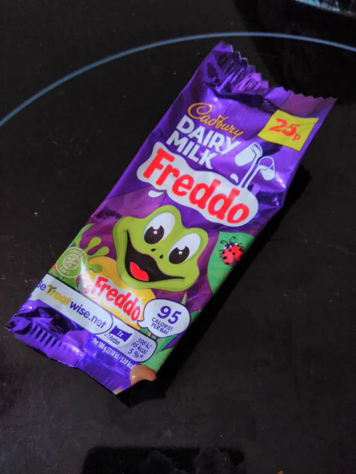 Freddo chocolate bar, in purple rectangular wrapper with small corner snipped off, molten chocolate coming out of cut corner