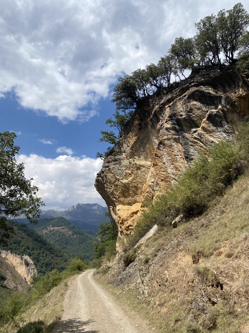 A dirt track passing by a large boulder in the Rio Cubo valley of the Picos de Europa national park