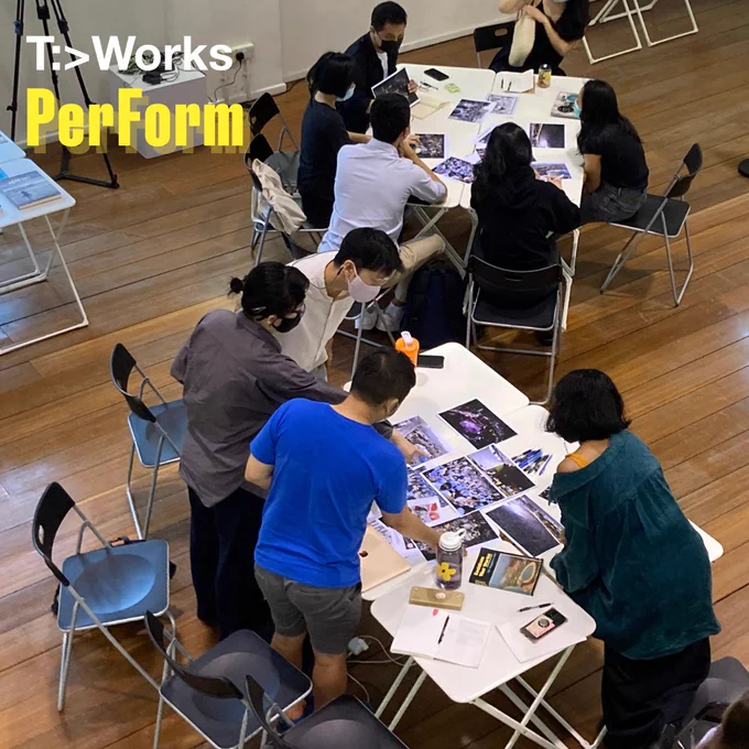 2. Participants gathered around to discuss images as part of a workshop activity