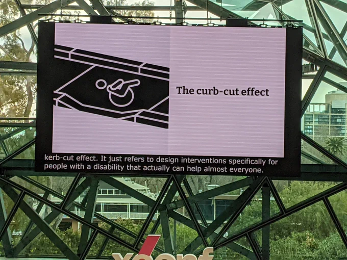 A conference slide with a picture of a path with a curb cut for wheel chair access.
CC from the talk, it refers to the design interventions specifically for people with a disability that actually can help almost everyone.
