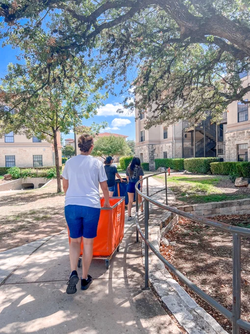 A mother pushes a cart on move in day. 