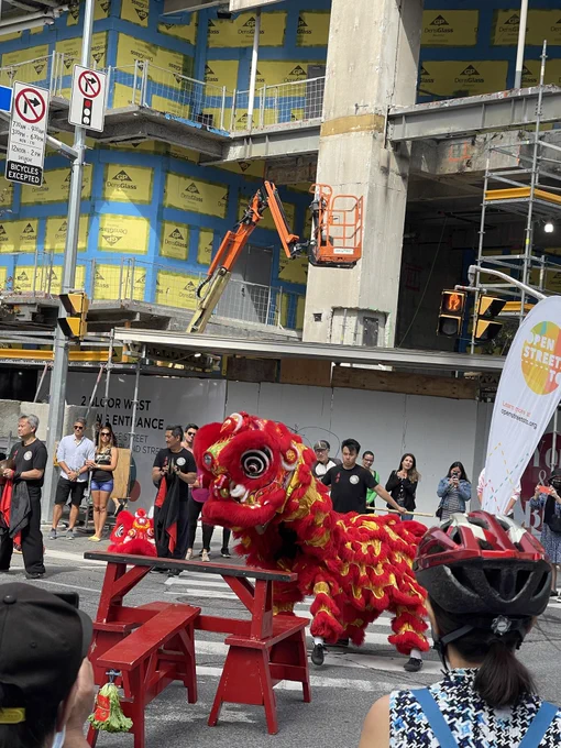 Two people dressed up together as some sort of dancing Chinese dragon. 