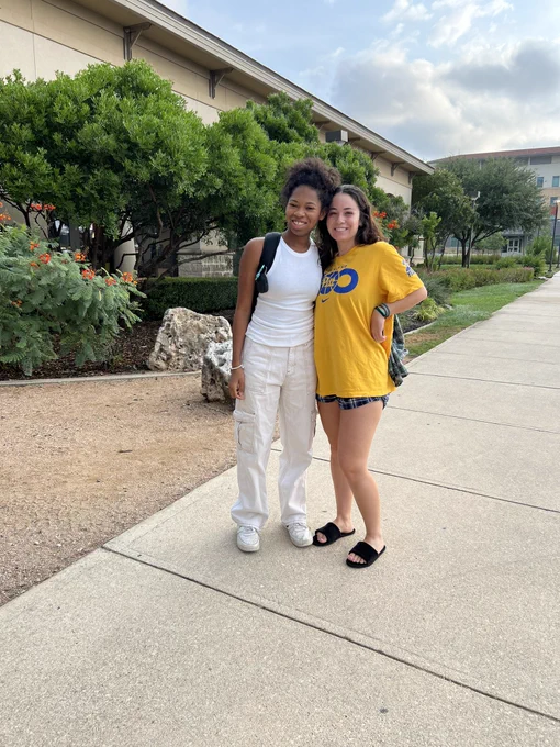 Two students smiling by the Roadrunner Cafe.