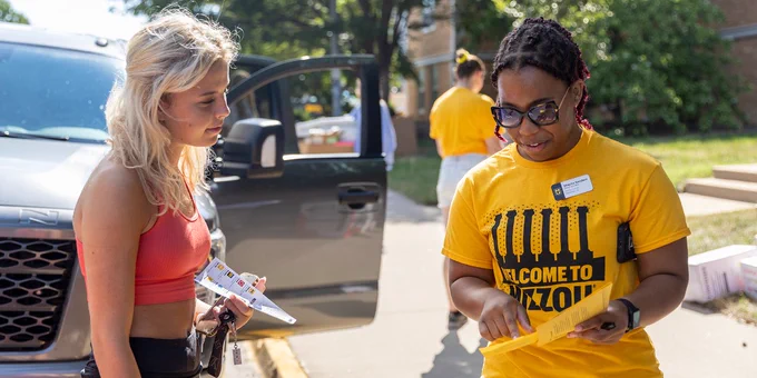 Volunteer providing directions to new student