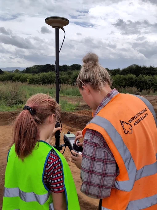 Archaeologist and a young volunteer creating a GPS site survey