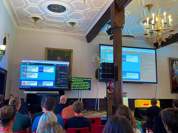 Michelle Barker on stage at SmashingConf presenting the usage of CSS container queries.