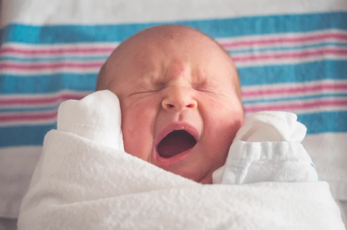 A young baby yawning.