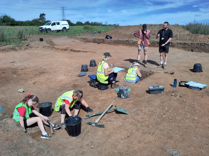 Volunteers in Trench 3 - two excavating a ditch slot and two recording with the assistance of a BSL interpreter.