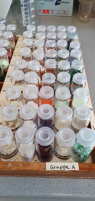 Reihen von kleinen Gläschen gefühlt mit bunten Chemikalien (Pulver und Flüssigkeiten)
