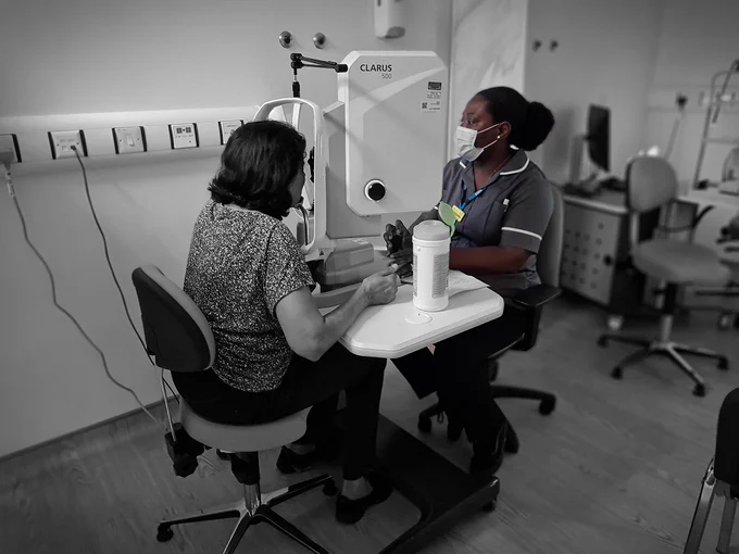 Ophthalmology technician performs a test on a patient.