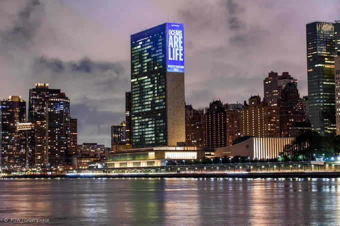 Greenpeace USA activists project messages calling for ocean protection onto the United Nations in New York.

Text reads: 'Oceans Are Life'