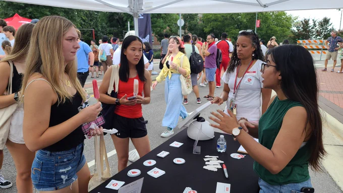 CCL speaking with student at the table at packapalooza 